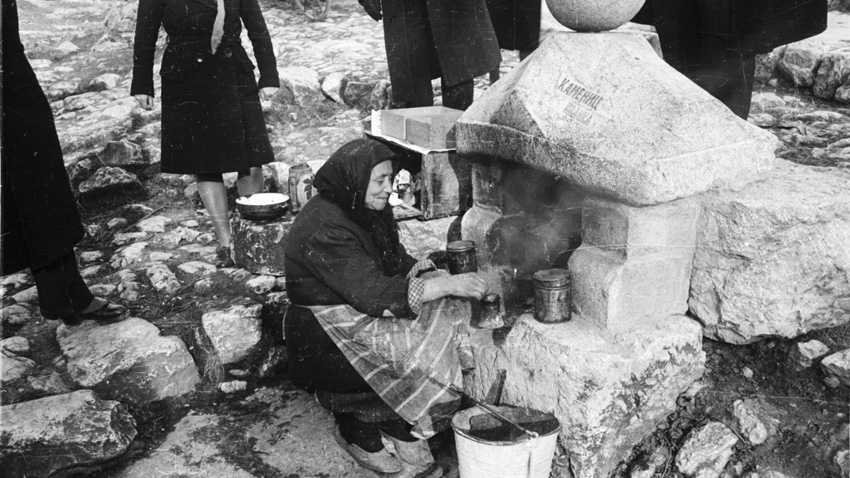 Grand-mère Eléna fait le café pour les voyageurs sur la route, 1940.