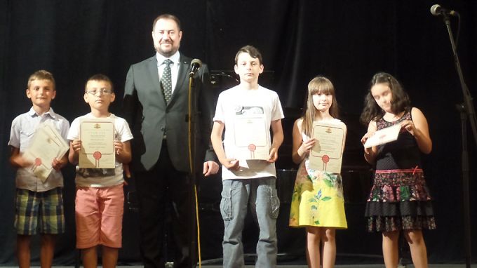 Председателят на ДАБЧ Петър Харалампиев с част от децата, наградени в конкурсите на Агенцията.
