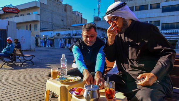 Собственик на магазин в Кувейт закусва заедно със свой работник на стария пазар в столицата