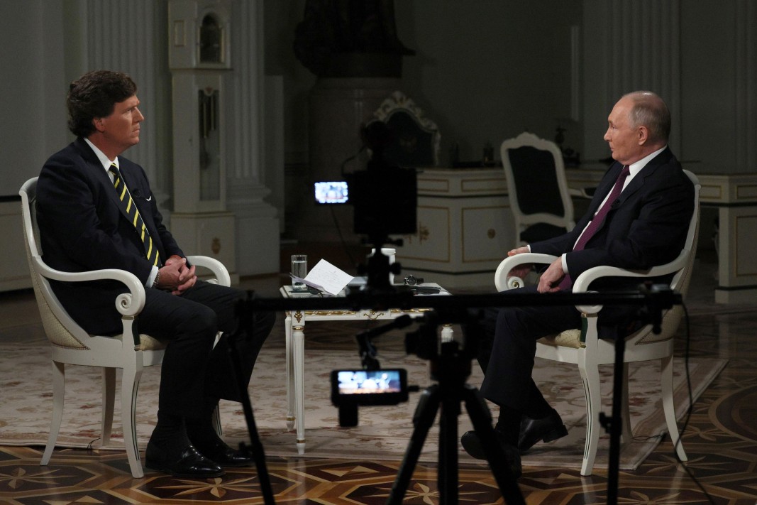 Такър Карлсън (вляво) и Владимир Путин