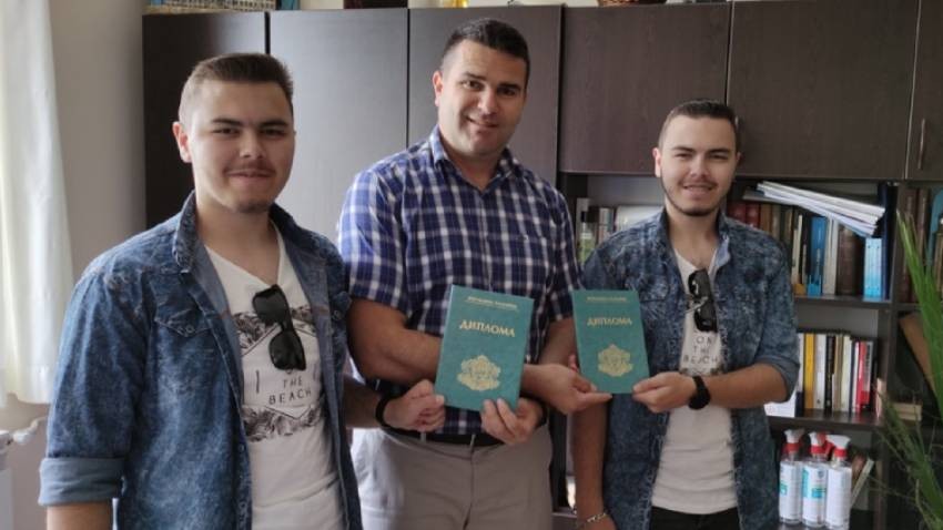 Ahmed Bozov 2021 yılı mezunlarından iki öğrenciye diplomarını takdim ederken.
