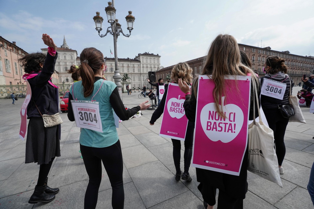 Активистите на комитета „Giusto Mezzo“ с розови банери с лозунг „Не е достатъчно“ организират флаш моб с мотото „Възстановяването не ни покрива“, в Торино, 18 април 2021 г. Протестиращите се събраха да изразят своята загриженост за проекта за План за възстановяване чрез фондовете на ЕС „Следващо поколение“- че той не е достатъчно пълен и не покрива нуждите например на жени, предприемачи и работници.