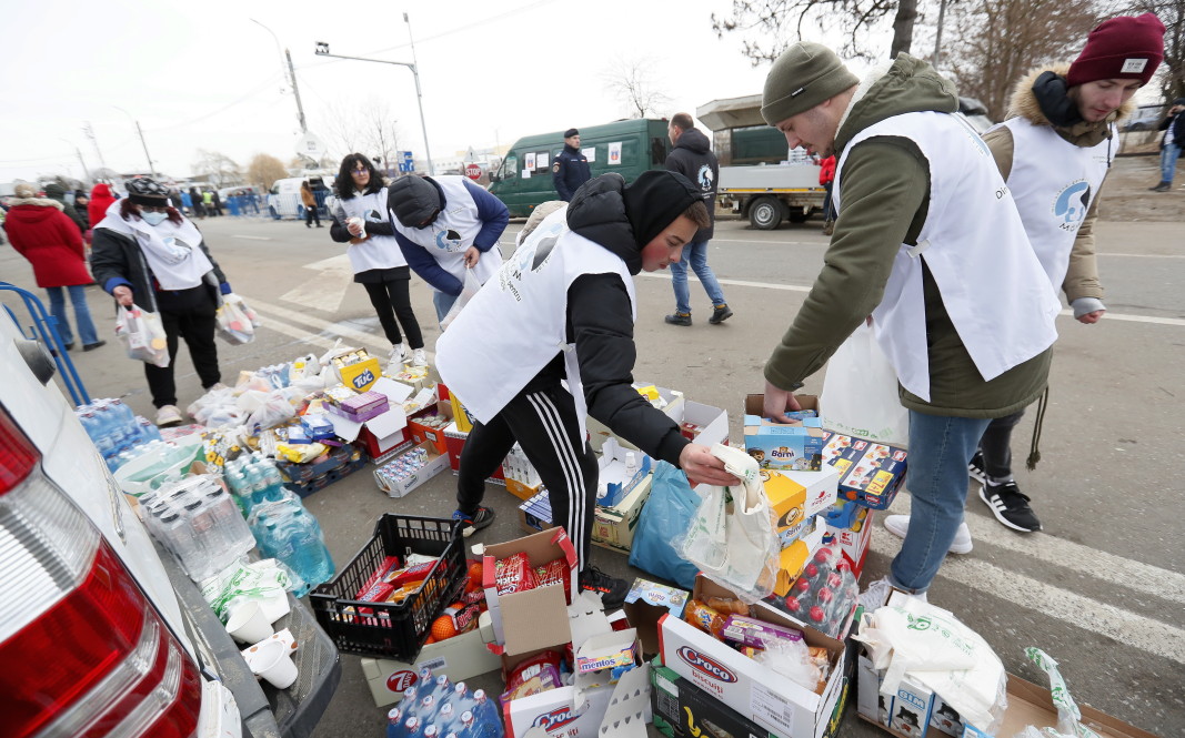 Румынские волонтеры подготавливают пакеты с водой и продуктами питания, чтобы раздать их бесплатно украинским беженцам, пересекающим границу у Сирета, Северная Румыния, 26 февраля 2022 г.