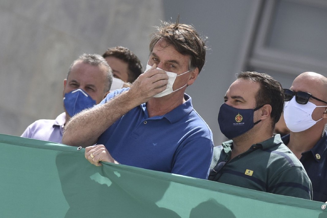 Президентът на Бразилия Жаир Болсонаро (в центъра) със защитна маска.