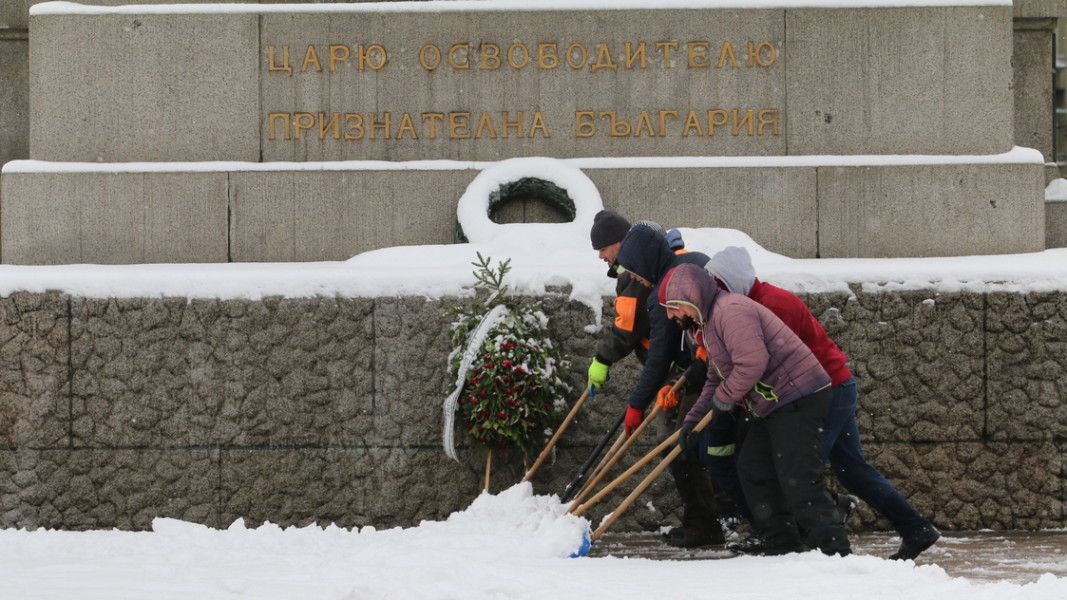 Работници почистват сняг пред Паметника на Цар Освободител в София  Снимка: БГНЕС