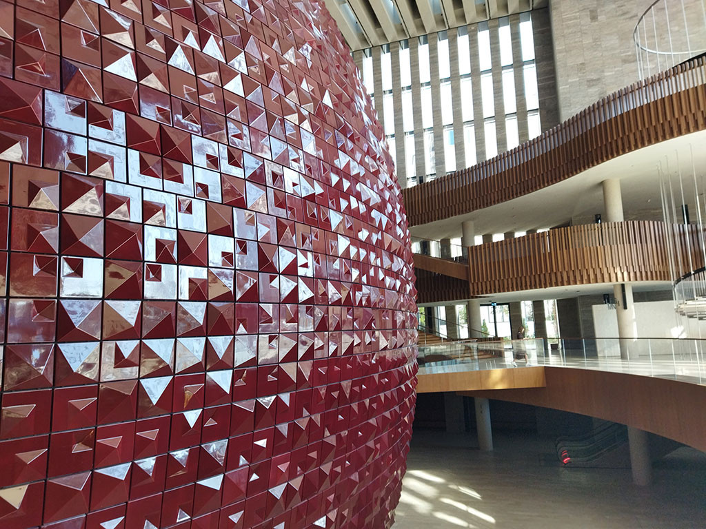 Концертната зала е оформена отвън като сфера, облицована с 15 000 ръчно изработени червени керамични плочки.