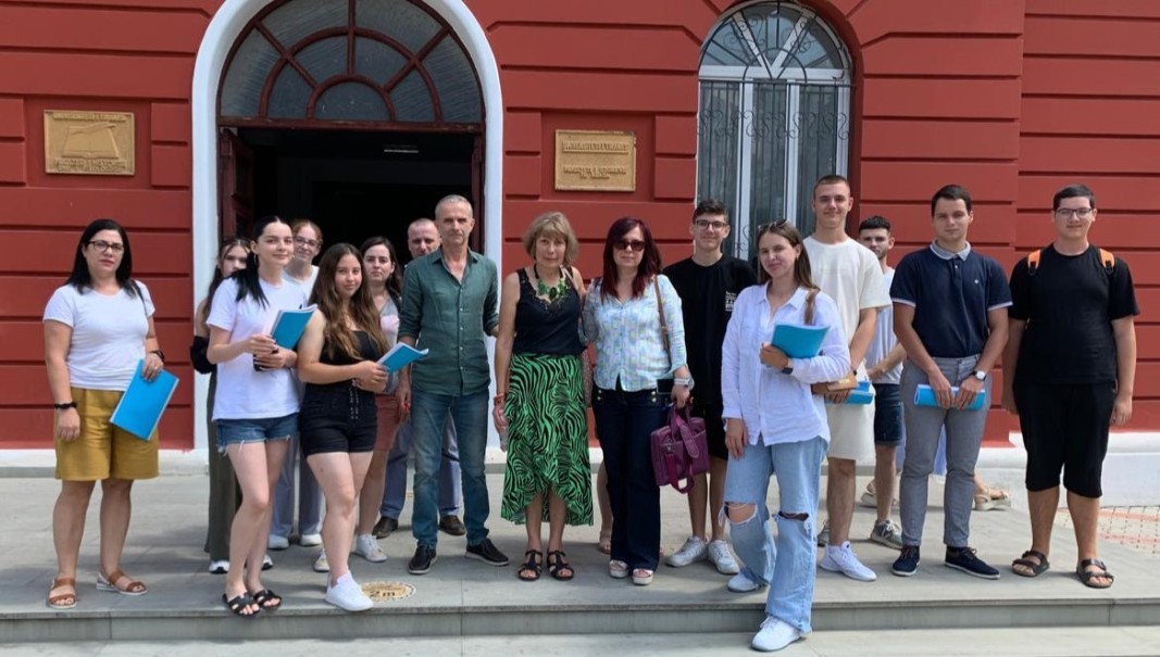 Associate Professor Belo with colleagues and students in front of the university building