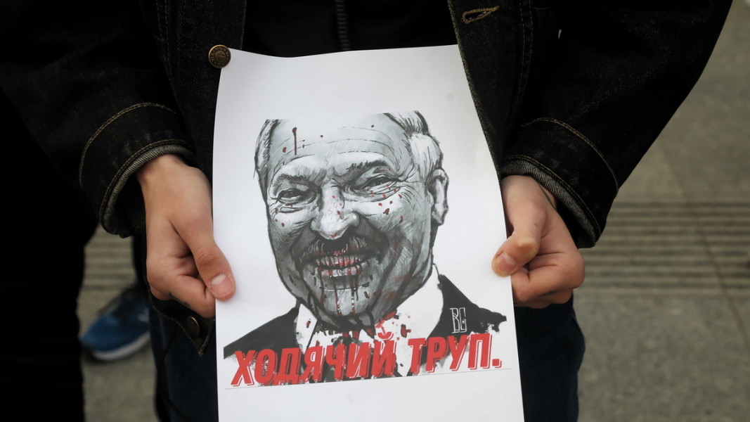  Протестиращи във Варшава държат портрет на водача на Беларус Александър Лукашенко с надпис „ Ходещ мъртвец “. 24 май 2021 година Снимка: ЕПА/БГНЕС 