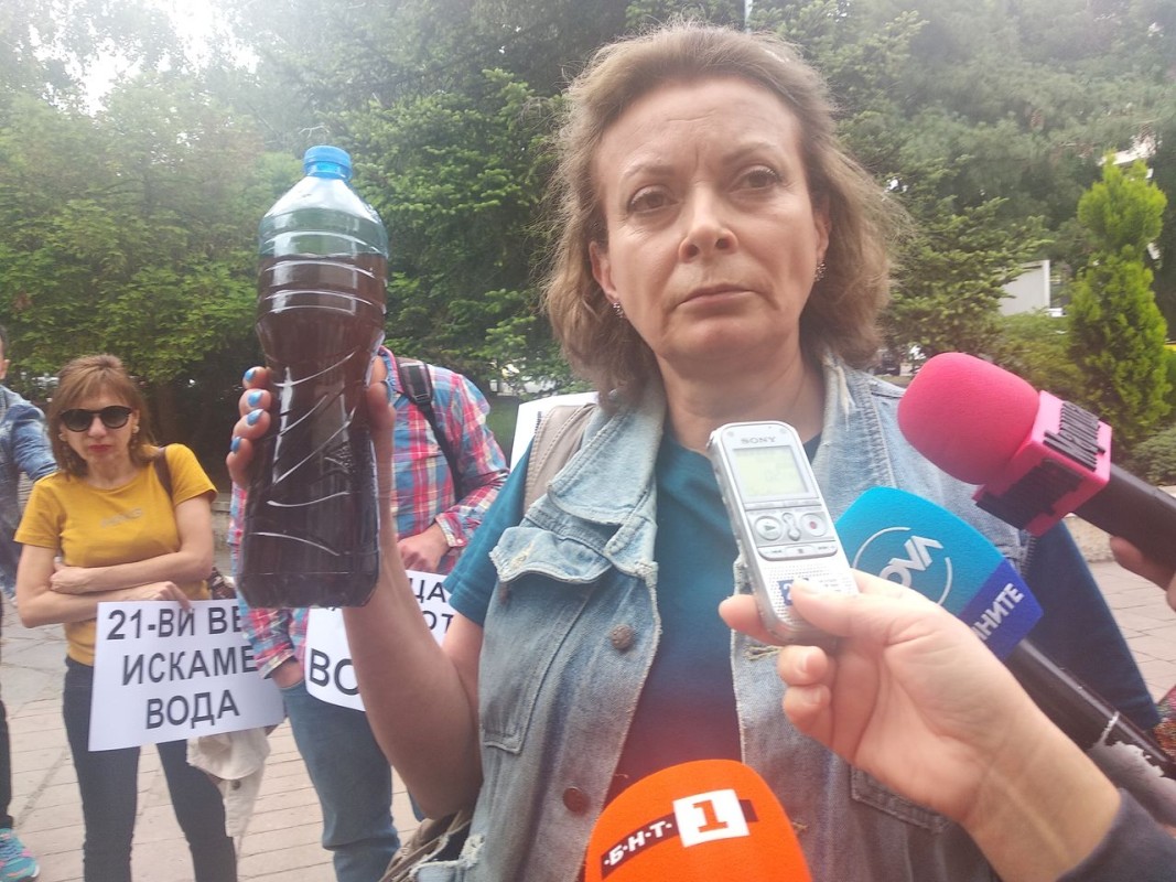 Демонстрантка държи шише с вода, за което твърди, че е от чешма в Брестовица. Снимка Кремена Данева