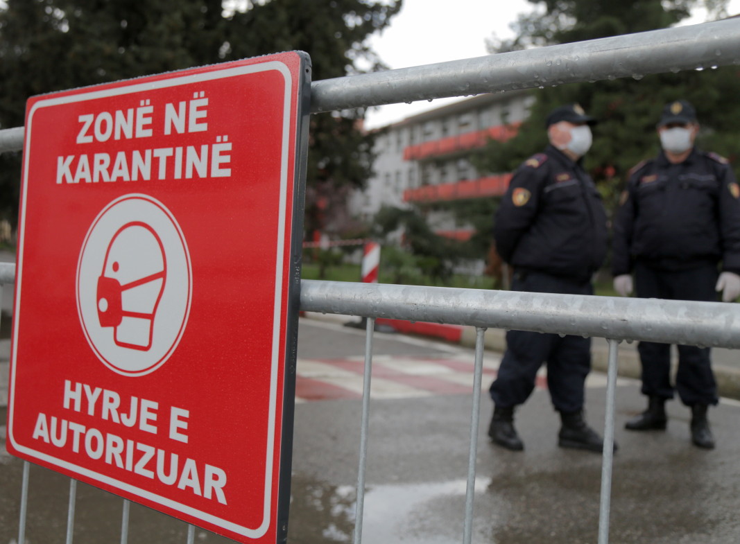 Албански полицаи зад ограда пред централната болница в Тирана, 09 март 2020 г. Албанските власти изолираха инфекциозното отделение и ограничиха всички социални дейности в страната, след като откриха първите два случая на пациенти, заразени с Covid -19.