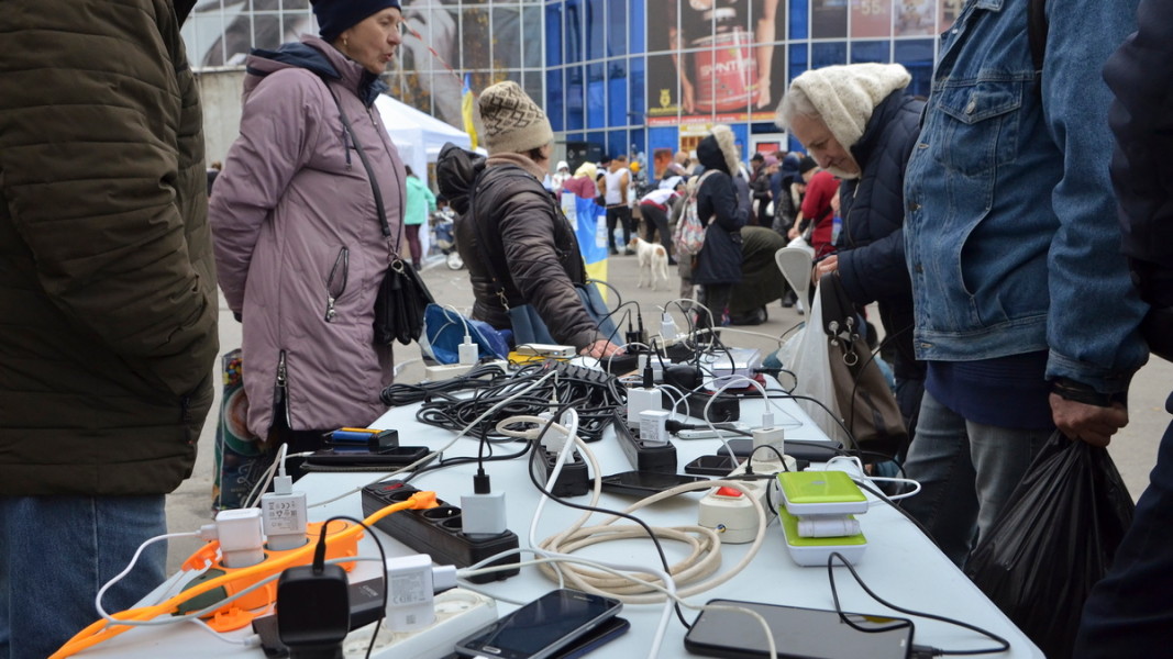 Местни жители зареждат мобилните си телефони от генератор на улицата в Херсон. 18 ноември 2022 г. Снимка: ЕПА/БГНЕС
