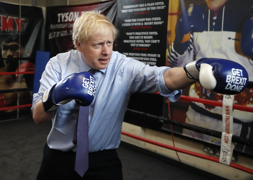 Борис Джонсън в клуб в Манчестър с боксови ръкавици с надпис на тях „Да изпълним Брекзит“. Снимка БТА