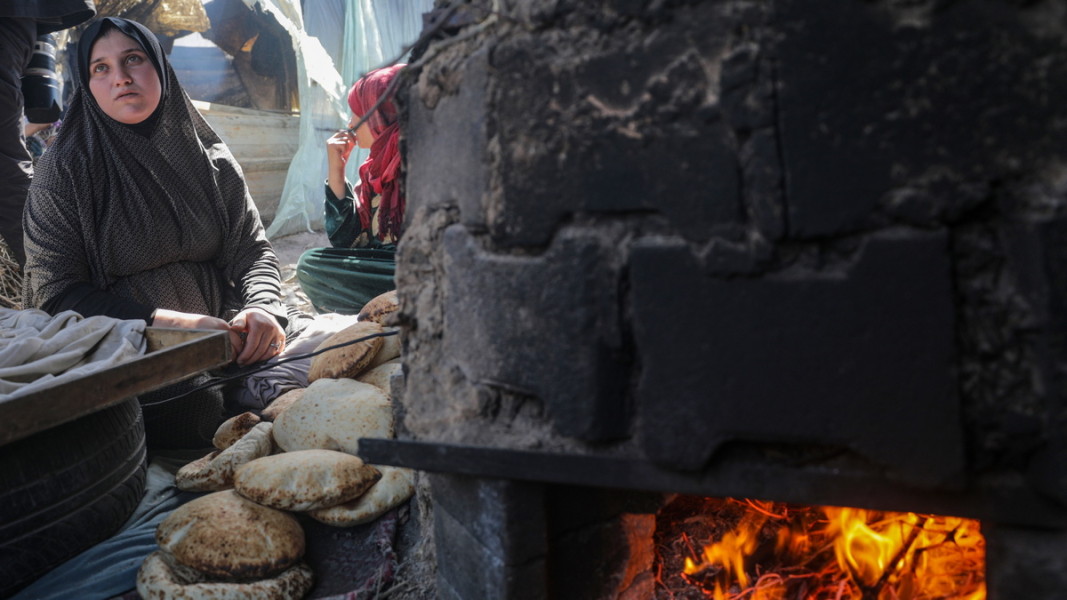 Разселена палестинка пече хляб в пещ на открито в южната част на Ивицата Газа, 8 март 2024 г. Снимка: ЕПА/БГНЕС