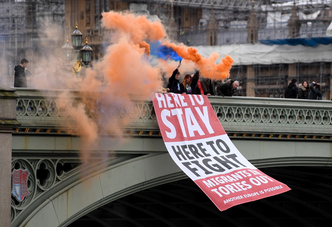 Привърженици на оставането в ЕС развяха транспарант с надпис „Тук ще останем, тук ще се борим. Имигрантите - вътре, торите - вън!“. Снимка: ЕПА/БГНЕС