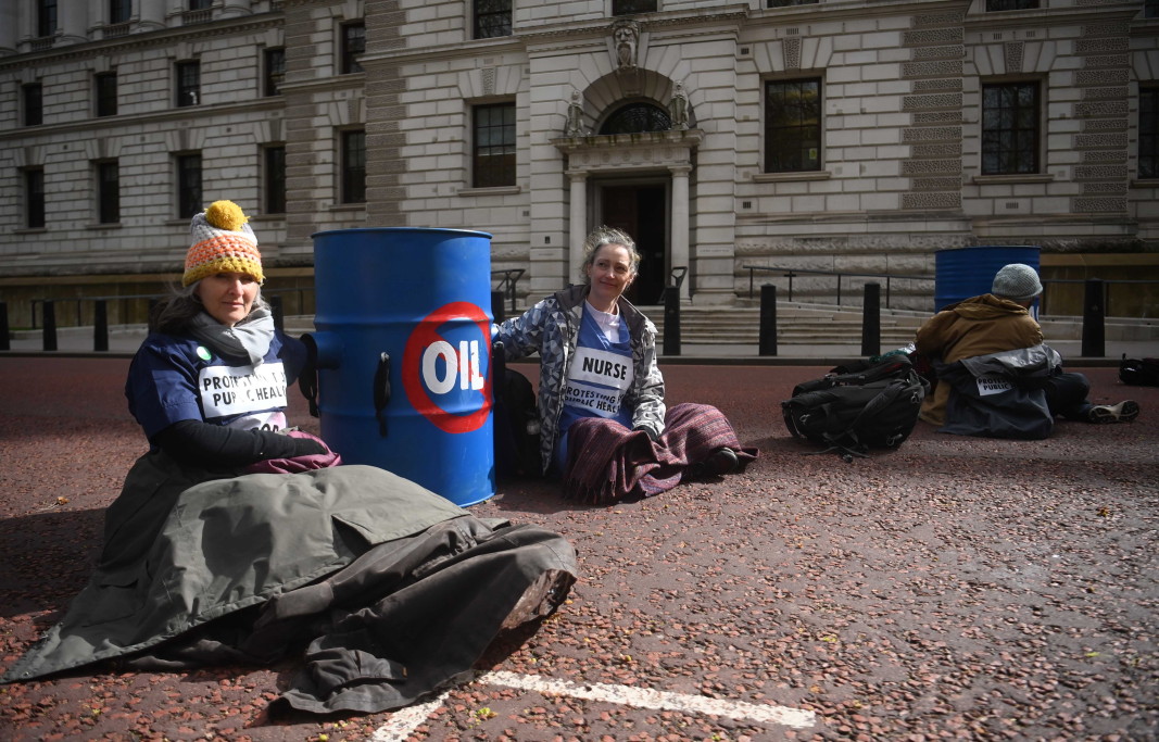 Участници в протест от групата Doctors for Extinction Rebellion са се залепили за контейнери за горива и са седнали пред Министерството на финансите в Лондон, 7 април 2022 г.
