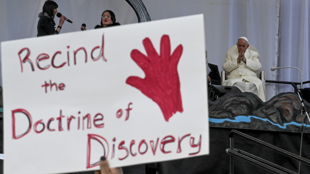 Плакат по време на папската визита в Канада призовава за отмяна на доктрината за откривателството, засегнала коренното население на новооткритите земи. Снимка: ЕПА/БГНЕС