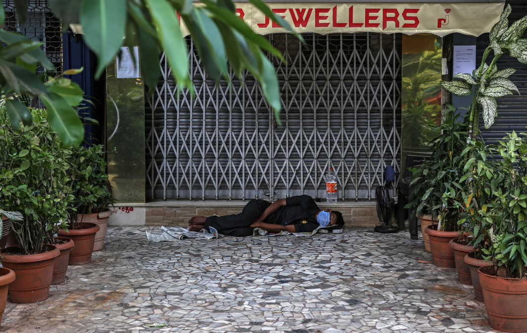 Охранител спи пред магазин в Мумбай, 3 април 2020 г.        Снимка: ЕПА/БГНЕС