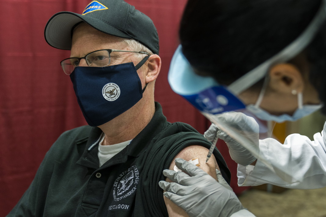 Изпълняващият длъжността министър на отбраната на САЩ Кристофър Милър получава първата доза от Covid ваксината на Pfizer-BioNTech в Националния военномедицински център Уолтър Рийд в Бетесда, Мериленд, 14 декември 2020 г.