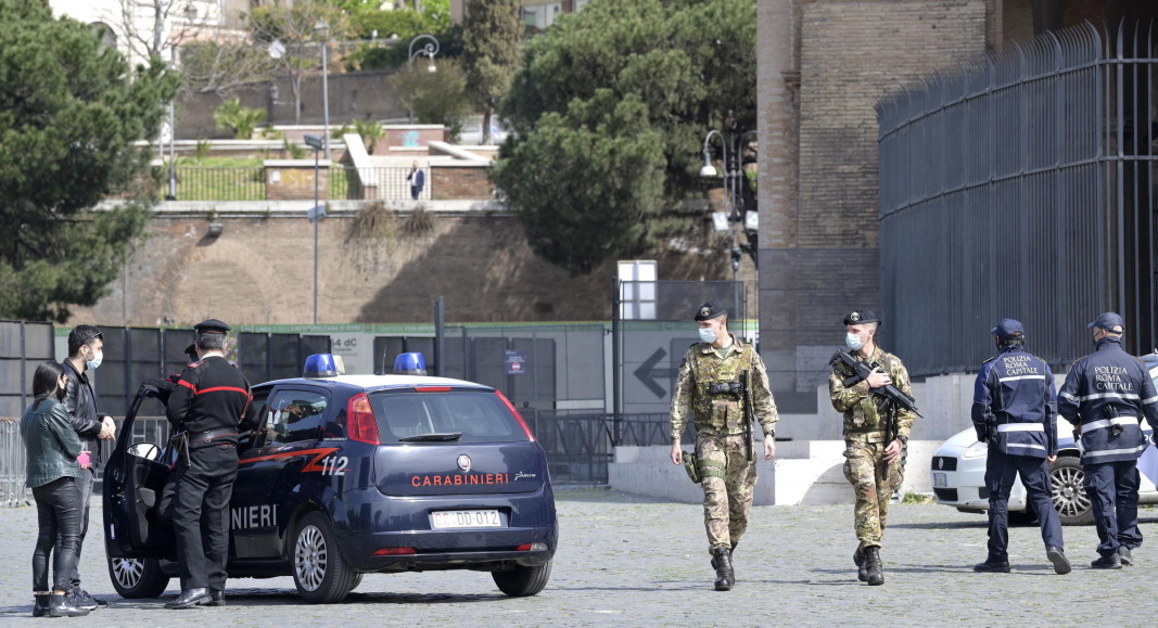  Военни и служители на реда в патрулират в Рим. Италия ще посрещне Великден с рестрикции, откакто държавното управление разгласи страната за „ алена зона “ на Covid-19 от 3 април, с цел да предотврати общественото взаимоотношение по празниците. 