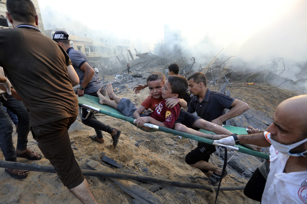 Палестинците евакуират две ранени момчета от разрушенията след израелските въздушни удари срещу град Газа, 25 октомври 2023 г.; АП/БТА