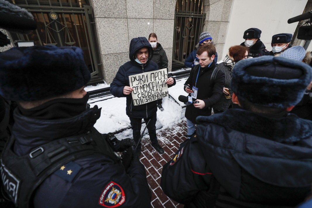 Поддръжник на правозащитната организация държи транспарант с надпис: Ръцете далеч от Мемориал. Свобода за политически затворници, докато тече изслушване по делото, на което Върховният съд разглежда искането на Руската прокуратура за ликвидиране на организацията, 14 декември 2021 г./ Снимка: ЕПА/БГНЕС