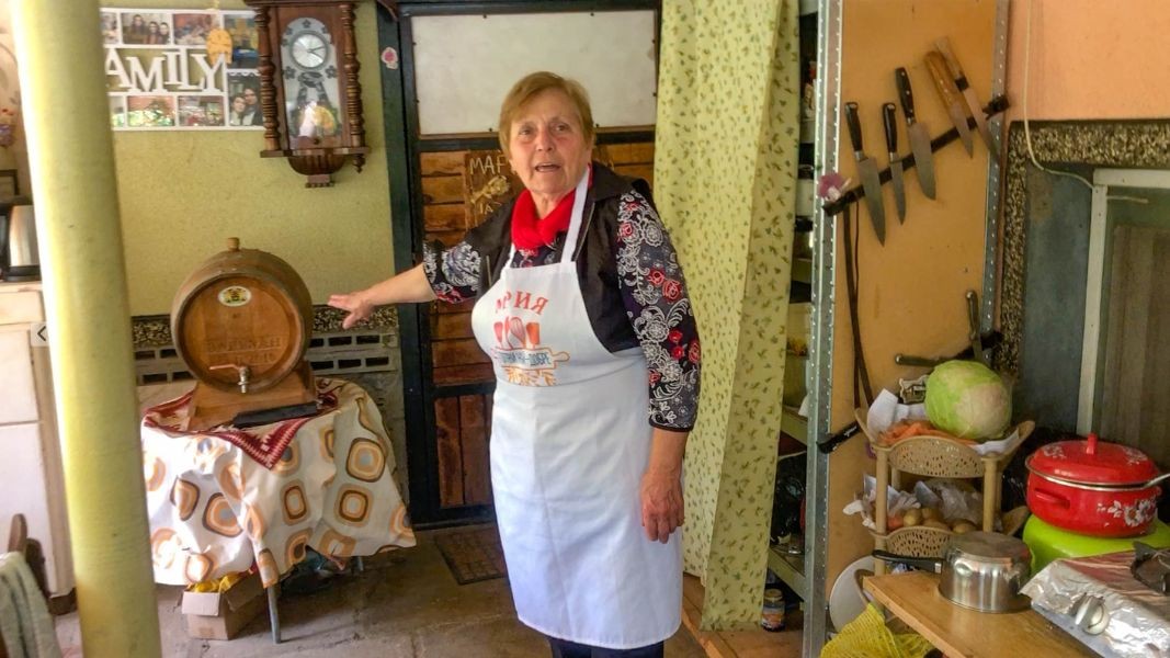 Marija Ivanova pret turistët në oborrin e shtëpisë së saj