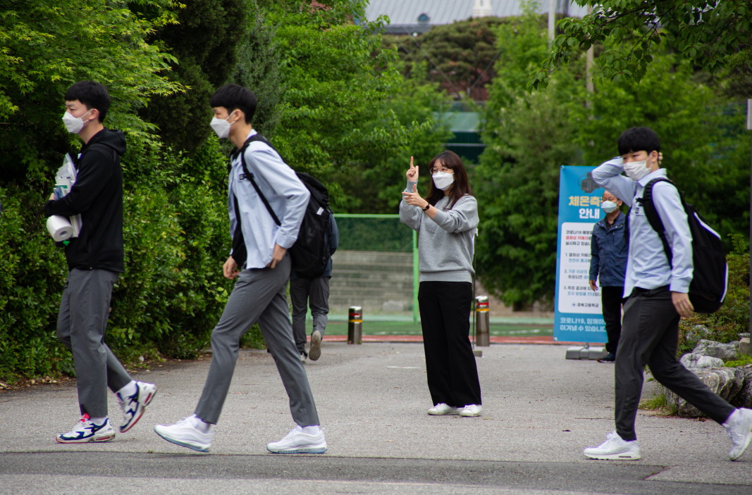 Ученици от гимназия в Сеул влизат в учебното заведение, след като температурата им е била проверена, 20 май 2020 г.