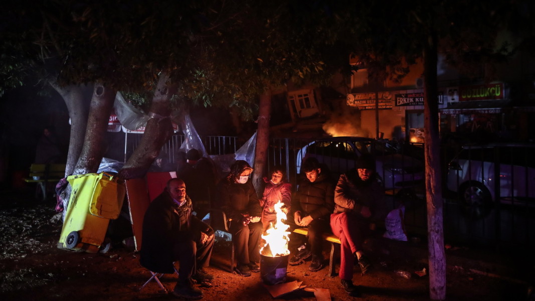 Residents in the Hatay province warm themselves by an open fire. The region is among the most hard hit areas in the devastating earthquake.