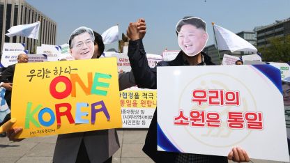 Активисти носят маски на Мун Дже-ин и Ким Чен-ун в подкрепа на среща между двамата.