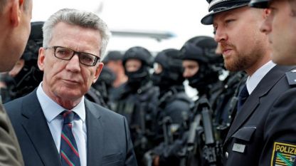 Германският министър на вътрешните работи Томас де Мезиер разговаря с полицаи, ангажирани с охраната на срещата на Г 20 в Хамбург