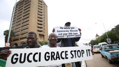 Протестиращи в Зимбабве държат плакат с призив: Спрете Грейс (Мугабе)
