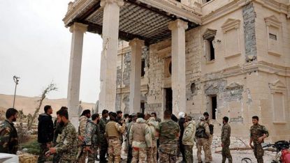 Войници от сирийската армия се събират край един от архитектурните обекти в Палмира след изтласкването на терористите извън античния град