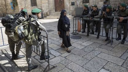 Мюсюлманка преминава през стария град на Йерусалим по време на петъчната молитва и засилени мерки за сигурност около джамията 