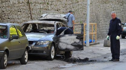 Хорватские полицейские осматривают подожженный автомобиль с болгарской регистрацией в городе Задар