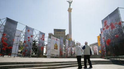 Възрастна двойка се разхожда на площад в Киев, украсен за честванията на Деня на победата срещу нацизма