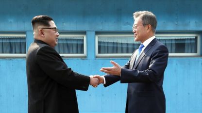Лидерите на Северна Ким Чен-ун (вляво) и на Южна Корея Мун Дже-ин се поздравяват на демаркационната линия в демилитаризираната зона между двете държави.
