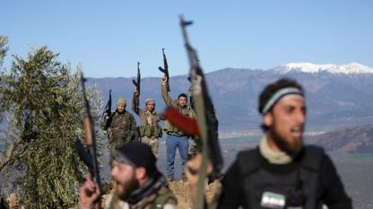 Подкрепяни от Турция бойци от Сирийската свободна армия размахват оръжия край град Африн в понеделник.