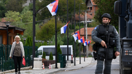 Въоръжен косовски полицай (вдясно) на пост в с. Банска, Косово, 27 септември 2023 г.