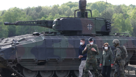 Германската министърка на отбраната Кристине Ламбрехт (втората отдясно наляво) на фона на танк Puma