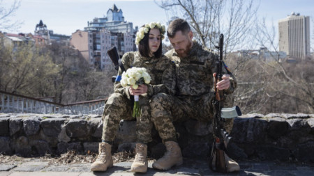 Анастасия (24 г.) и Вячеслав (43 г.) от украинската териториална отбрана празнуват сватбата си в условия на военно положение в Киев, 7 април 2022 г.