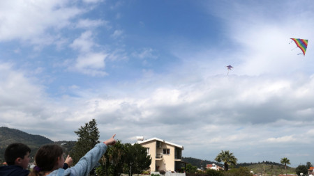 Деца наблюдават хвърчила в небето, Корнос, Кипър, март 2022 г.