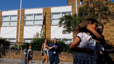 Ученици и персонал напускат католическото училище Корпус Кристи в Лондон, 4 септември 2023 г.  Това е едно от над 100 училища във Великобритания, които трябва да преместят ученици поради проблеми със строителство с газобетон (RAAC).