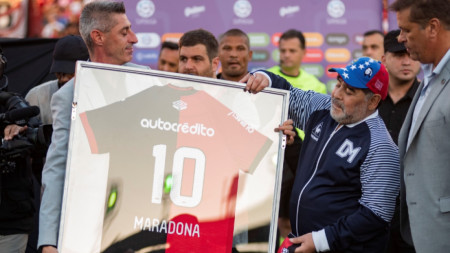 Диего Марадона получава подарък фланелка от президента на Нюелс Олд Бойс Едуардо Бермудес.