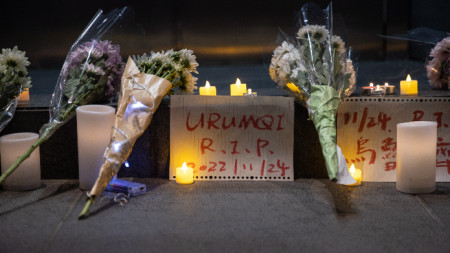 Цветя са оставени от опечалени за жертвите на пожара в Урумчи, който уби 10 души, останали заключени заради политиката за 