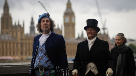 Британци, облечени в стила на 19 век, се отправят, за да отдадат почит на покойната кралица Елизабет II в Уестминстър Хол в Лондон, 15 септември 2022 г.