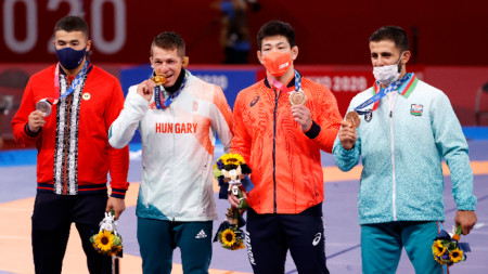 Тамаш Лоренц от Унгария е захапал златния си медал след награждавенот на борците в ксат. до 77 кг.