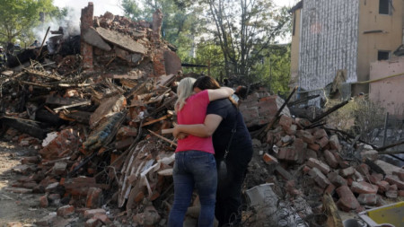 Жени се прегръщат край останките на сграда след руски обстрел в района на Салтивка край Харков, 18 август 2022 г.