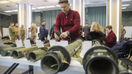 Журналисти и посетители разглеждат оръжия и екипировка на армията на Русия, изложени във Военния медиен център в Киев, 12 януари 2023 г.