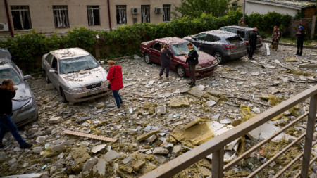 Хора проверяват автомобилите си, паркирани близо до мястото на обстрел в жилищен район в Харков, Украйна, 14 май 2024 г. 