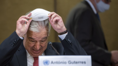 Генералният секретар на ООН Антониу Гутериш сваля маската си за пресконференцията в Женева.